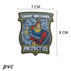 A dark embroidered patch featuring Saint Michael with wings and a shield, with the text Protect Us.