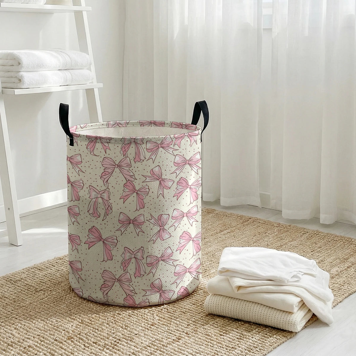 A large, cylindrical laundry basket with a pink and white floral bow pattern sits on a woven mat.