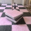 A pink and gray checkered rug mat with stacked pink fluffy mats and a black figurine on a floor.