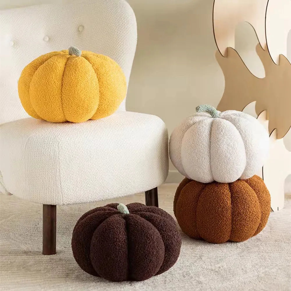 A collection of fluffy, round pumpkin plush decorations in yellow, white, and brown tones displayed on a light surface.