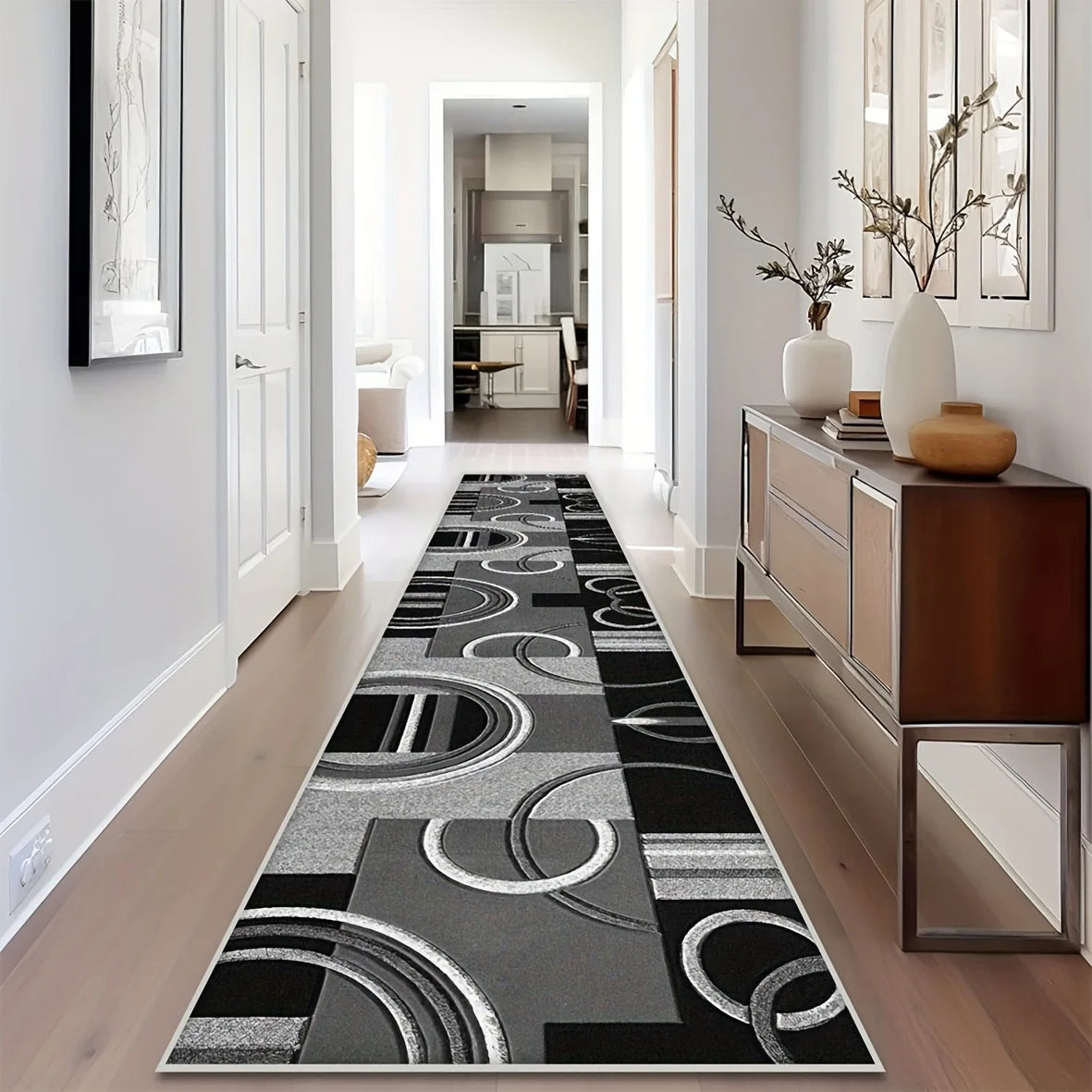 A long, narrow modern geometric area rug with black and white circular patterns placed in a bright hallway.