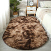 A fluffy brown plush floor mat placed on a light gray floor next to a white bed and wooden storage box.