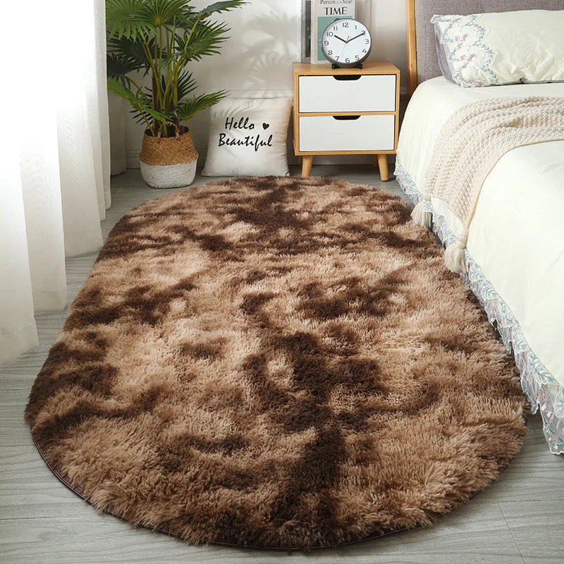 A fluffy brown plush floor mat placed on a light gray floor next to a white bed and wooden storage box.