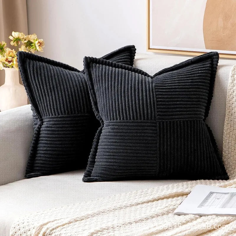 Black striped corduroy lumbar support pillow cushion resting on a light-colored sofa.