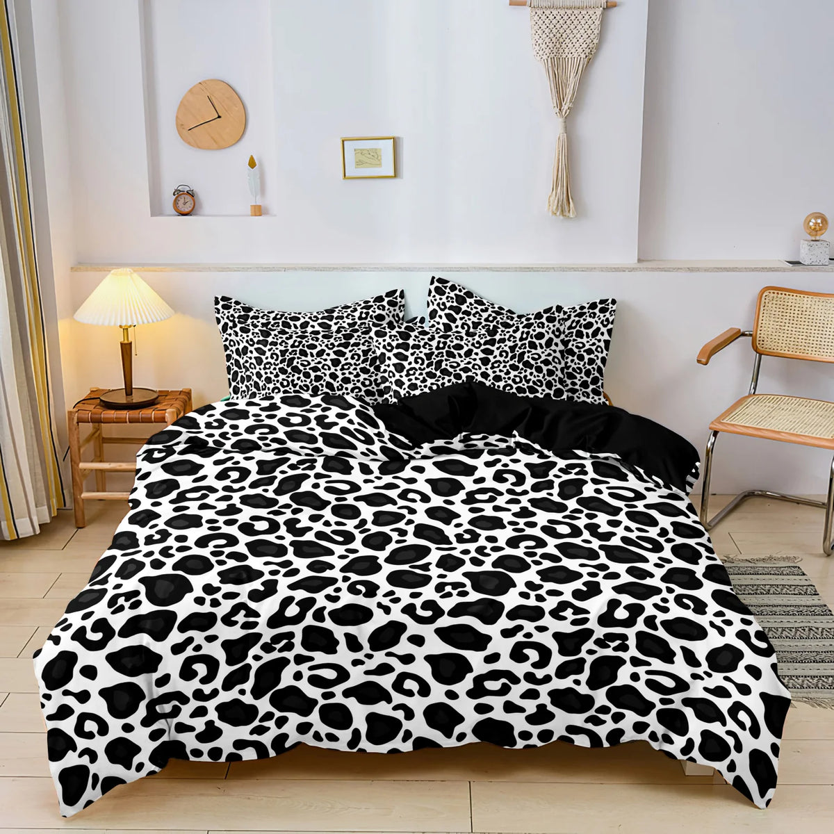 A leopard print duvet cover set featuring black and white spots displayed on a bed.