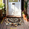 A circular doormat made of various natural stones and shells placed on a wooden floor.