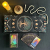 A black storage pouch for a Mystical Tree of Life Tarot card, next to a candle and a deck of tarot cards.