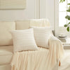 Two white textured striped velvet throw pillow covers draped on a light-colored sofa.