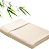 A beige bamboo fiber flat bed sheet folded neatly with green leaves in the background.