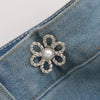 Silver floral pearl adjustable metal waist clip attached to a denim fabric