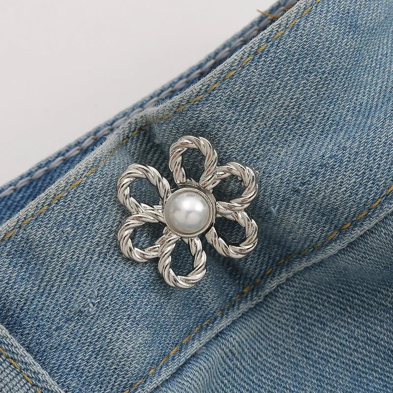 Silver floral pearl adjustable metal waist clip attached to a denim fabric