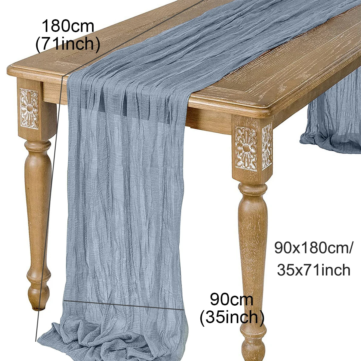 A grey semi-sheer gauze table runner draped over a wooden table, showing its length and texture.