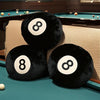 A close-up of black memory foam ball pillows resting on a teal billiard table.
