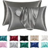A collection of silky satin pillowcases in various shades including gray, silver, black, red, pink, and green.