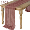 A piece of dusty rose semi-sheer gauze fabric draped over a wooden table.