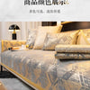 A close-up of a luxury velvet sofa cover featuring a gray and gold geometric pattern on a bed or sofa.
