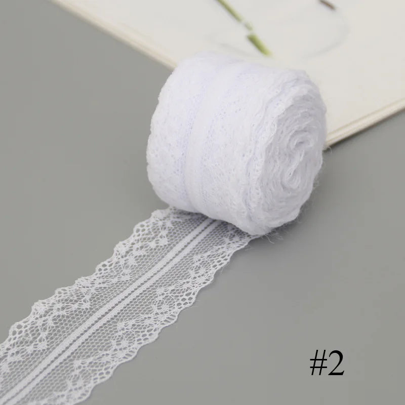 A roll of white floral lace ribbon with cotton trim for sewing and crafts.