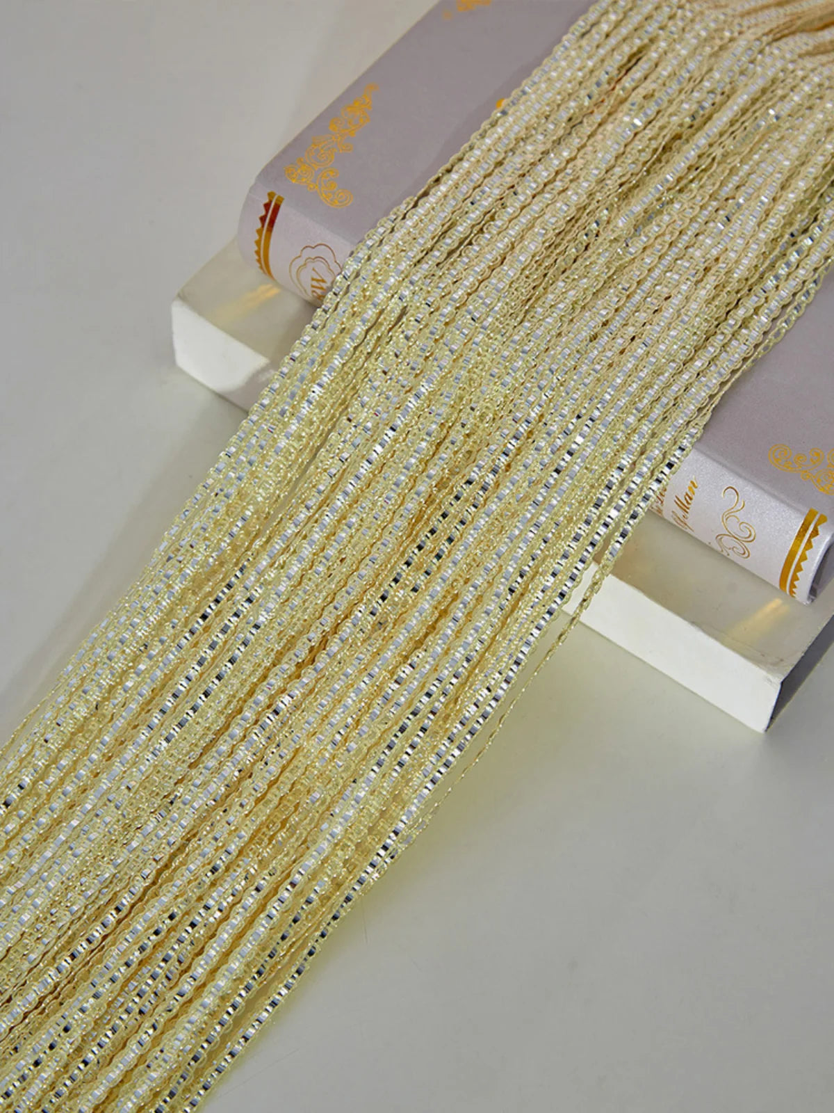 Golden decorative door string curtains displayed next to a book.