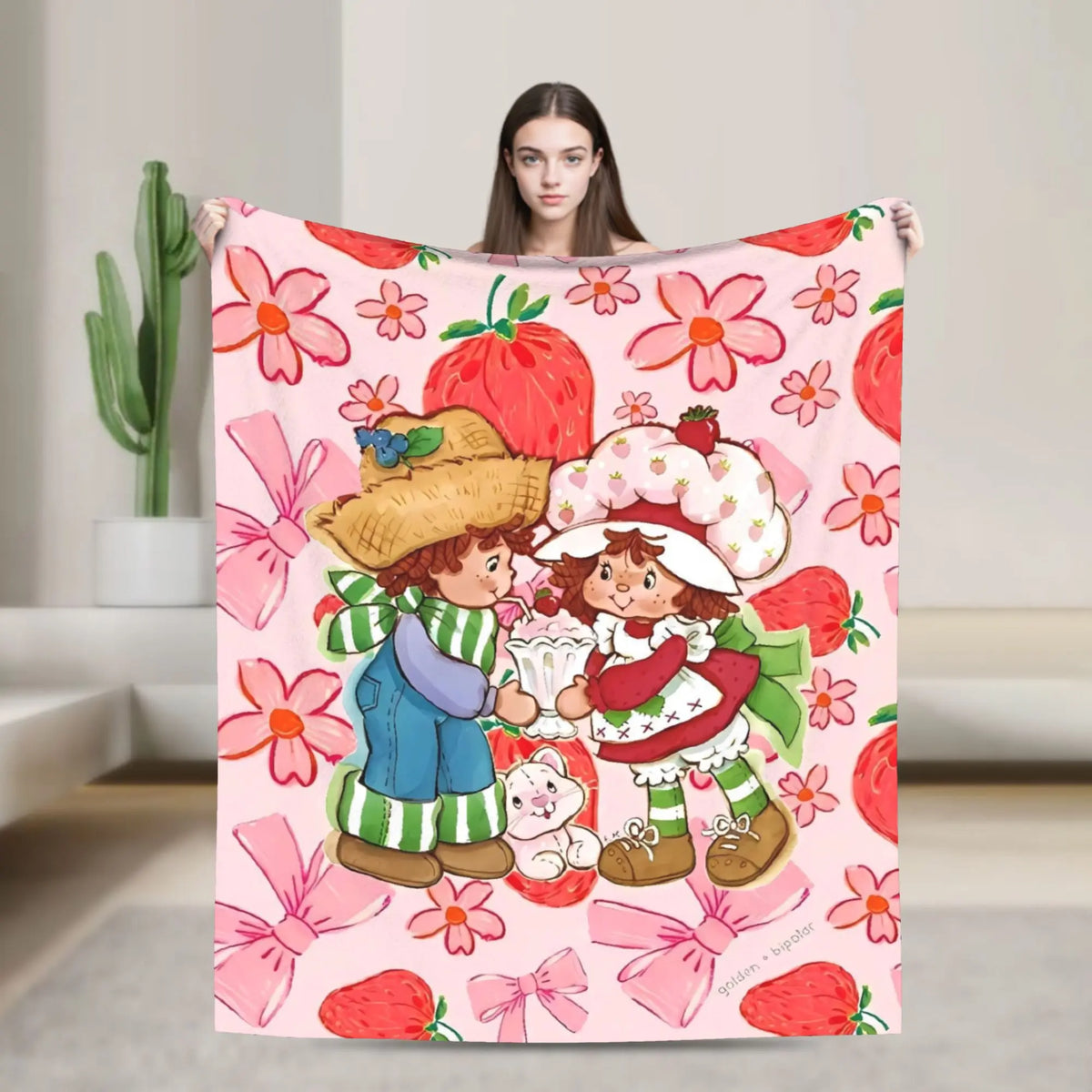 A pink strawberry shortcake plush throw blanket featuring fruit and floral patterns.