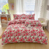 A pink and white floral print duvet cover set with matching pillowcases displayed on a bed.