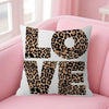 A decorative pillow cover featuring the word LOVE in a leopard print design on a pink sofa.