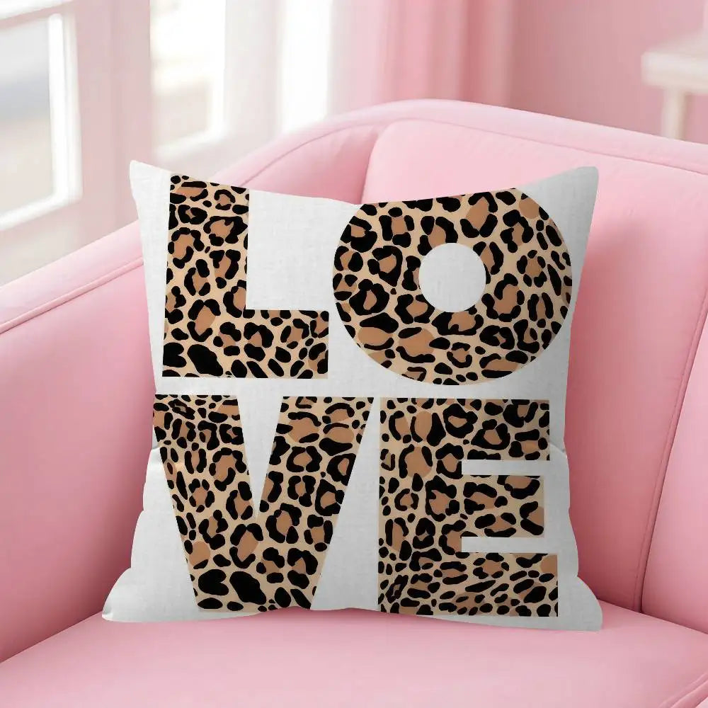 A decorative pillow cover featuring the word LOVE in a leopard print design on a pink sofa.