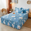 A light blue floral printed bed skirt covering a bed in a bedroom setting.