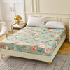 A floral fitted sheet set with pillowcases displayed on a bed, featuring light green and pink flowers.
