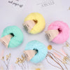 A collection of pink, yellow, and turquoise organic cotton yarn skeins displayed on a white background.