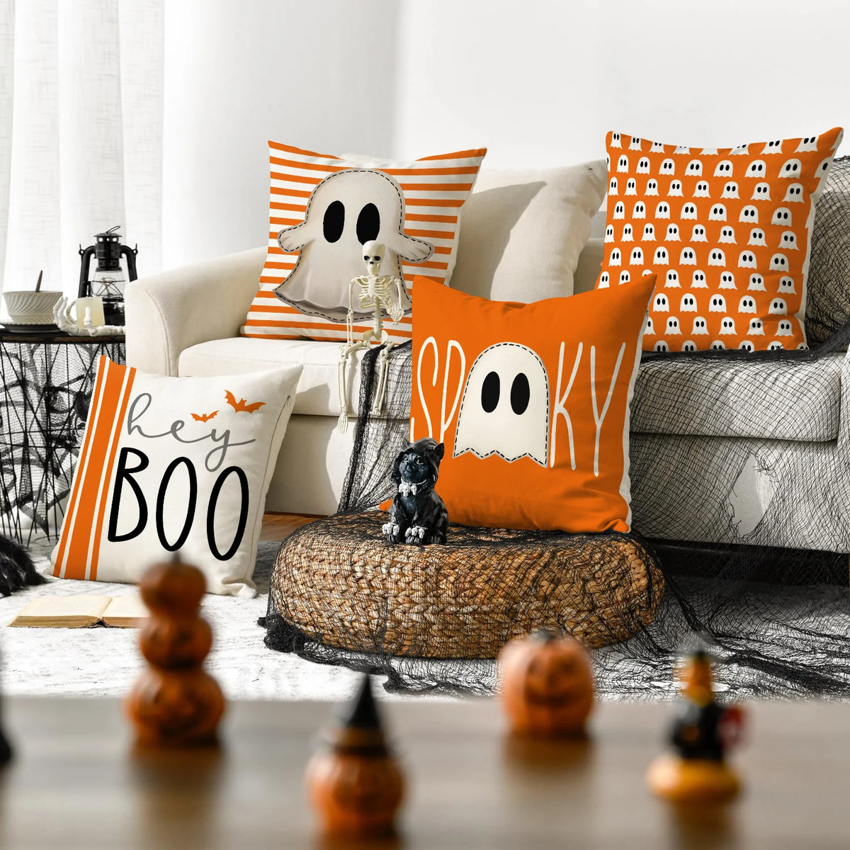 A set of four Halloween cushion covers featuring ghost, pumpkin, and skull designs in orange and white.