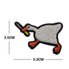 A black and white embroidery patch of a duck with an orange beak and feet.