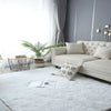 A fluffy white shag rug placed on a light gray floor in a modern living room setting.