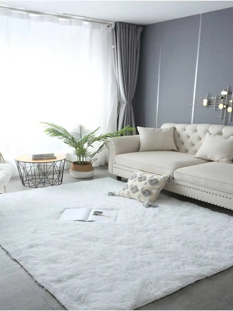 A fluffy white shag rug placed on a light gray floor in a modern living room setting.