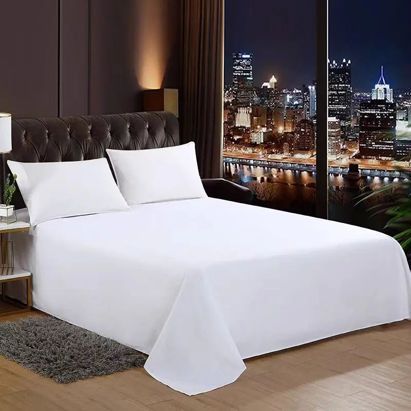 White premium flat bed sheet spread on a bed with dark headboard and a city skyline view outside the window