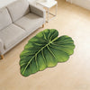 A large, green leaf-shaped quick-dry bathroom mat with a rubber backing placed on a light wooden floor.