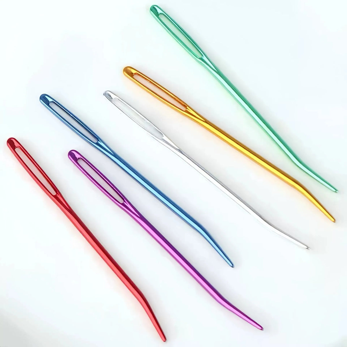 A collection of 20 aluminum knitting needles and sewing pins in various colors including green, gold, and purple.