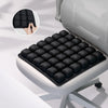 A black adjustable press-to-inflate seat cushion is shown being placed on a light gray chair seat.