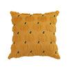 A square throw pillow covered in orange fabric featuring a repeating pattern of small green pumpkin shapes.