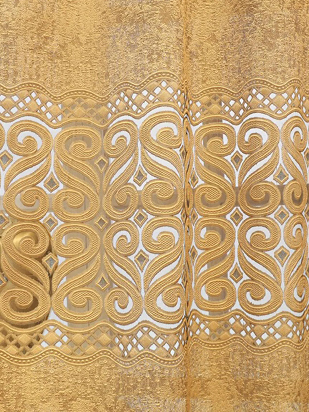 Close-up of a gold hollow perforated curtain featuring intricate white decorative embroidery.