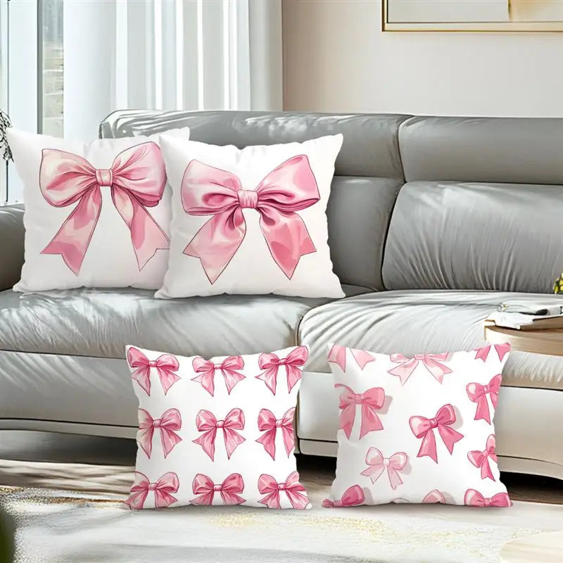 Decorative pillow covers featuring a pink bow pattern on white fabric.