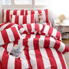 A red and white striped duvet cover set with pillows and a small rabbit figurine displayed on a bed.