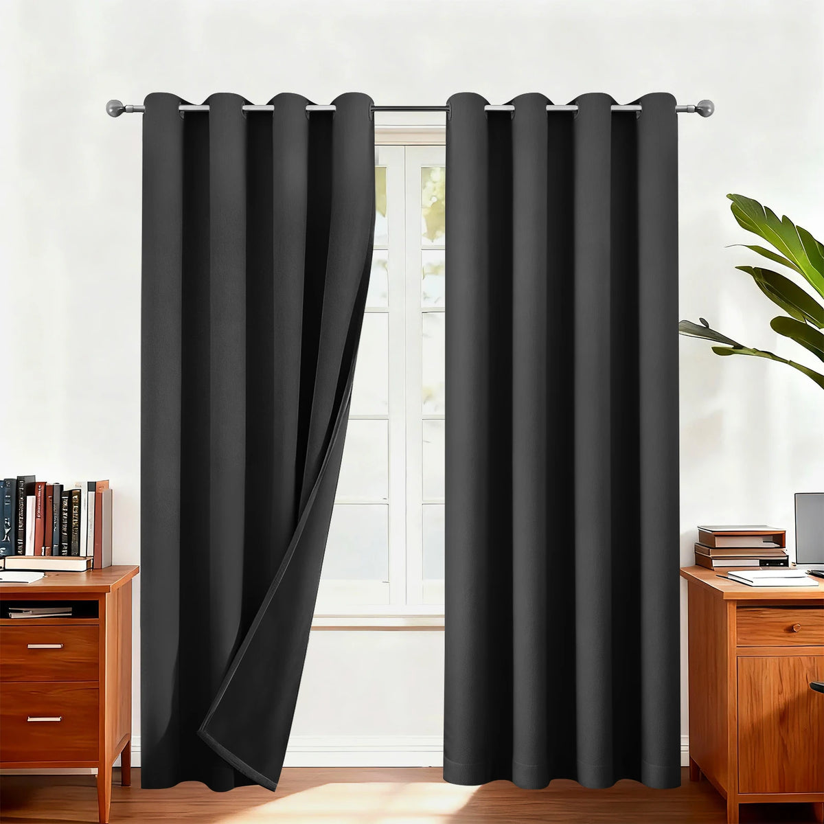Blackout thermal window drapes hanging on a rod in a bright room.