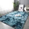 A deep teal faux fur rug placed on a floor, with an open book and a framed print nearby.