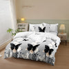 A white duvet cover set with a black and gray butterfly print displayed on a bed in a light-colored room.