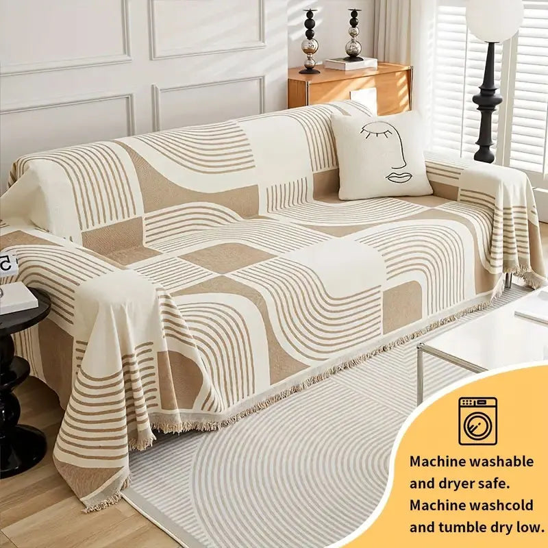 A beige and white striped sofa cover featuring a modern face design, displayed on a light-colored floor.