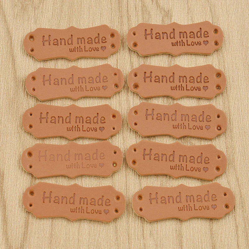 A collection of 10 handmade PU leather tags with the text Hand made with Love embossed on them.