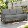 Gray woven outdoor sofa seat slipcover placed on a wooden deck with greenery in the background.