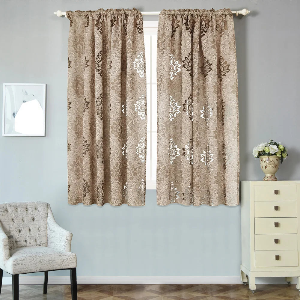 A pair of beige sheer jacquard curtain panels with floral patterns hanging in a window.
