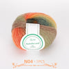 A ball of multi-colored wool yarn with shades of orange, green, and brown.