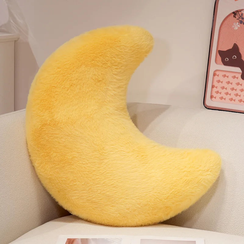 A bright yellow moon-shaped throw pillow with a fluffy texture.